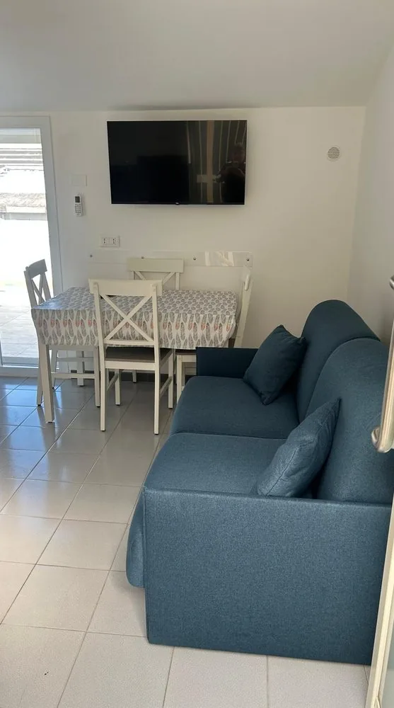 Divano letto blu e TV in soggiorno